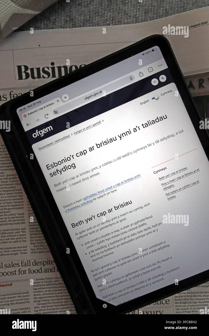 Welsh-language Ofgem energy price cap information on a tablet, explaining household gas and electricity charges in Wales. Stock Photo