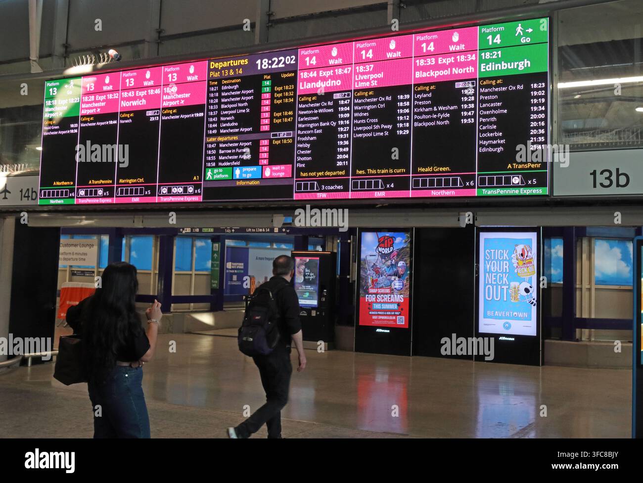 Electronic departure boards for Manchester Piccadilly through platforms 13 and 14, used by busy cross-city rail services. Stock Photo