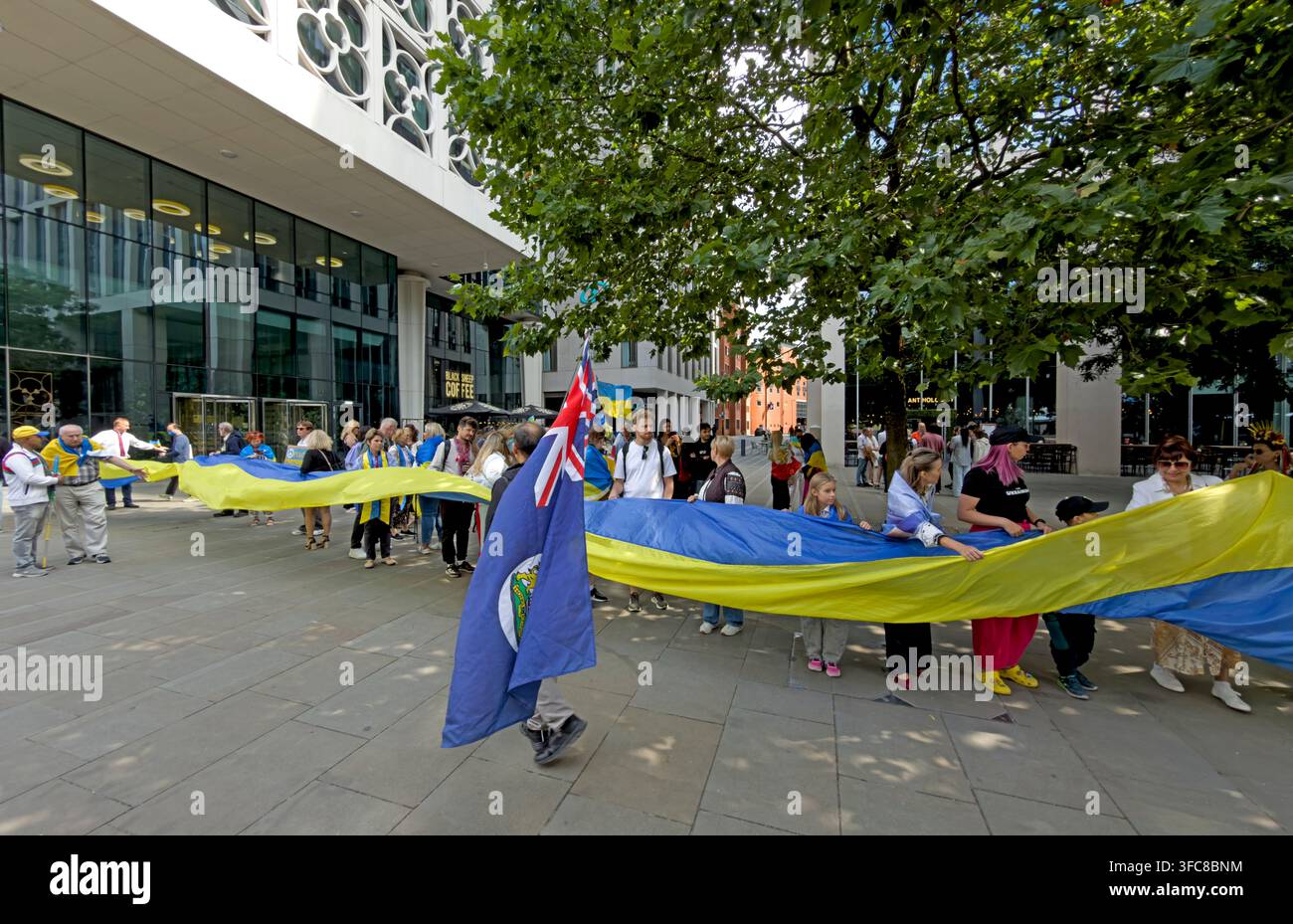 Ukrainian Independence Day gathering with a long blue-and-yellow flag in St Peter’s Square, Manchester, 22 August 2026. Stock Photo