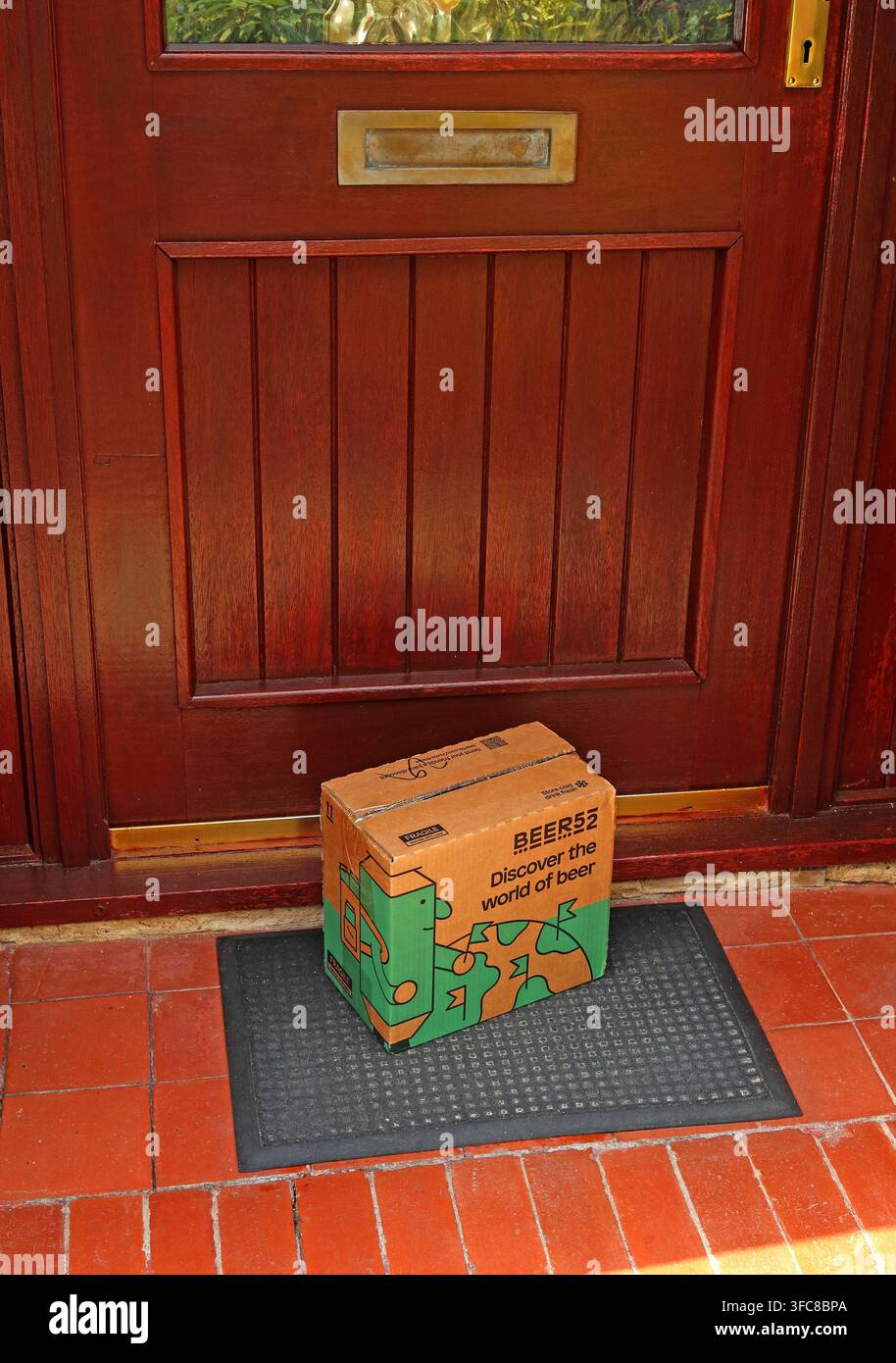Branded Beer52 beer box left in plain sight outside a front door, highlighting unattended delivery and doorstep online & alcohol theft concerns. Stock Photo