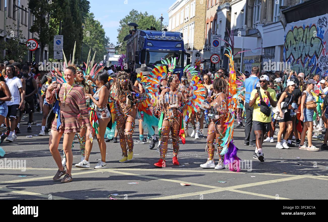 Wide view of the Notting Hill Carnival procession and costumed dancers on a crowded west London street in 2025. Stock Photo