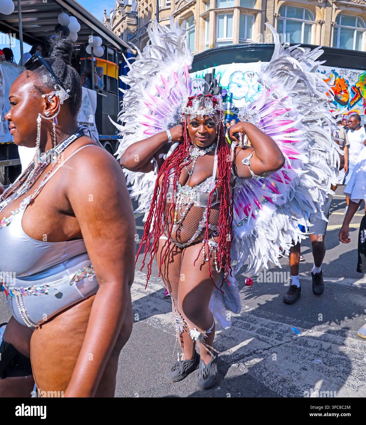 Masquerader in a feathered costume on the Notting Hill Carnival route during London’s 2025 August Bank Holiday festival. Stock Photo