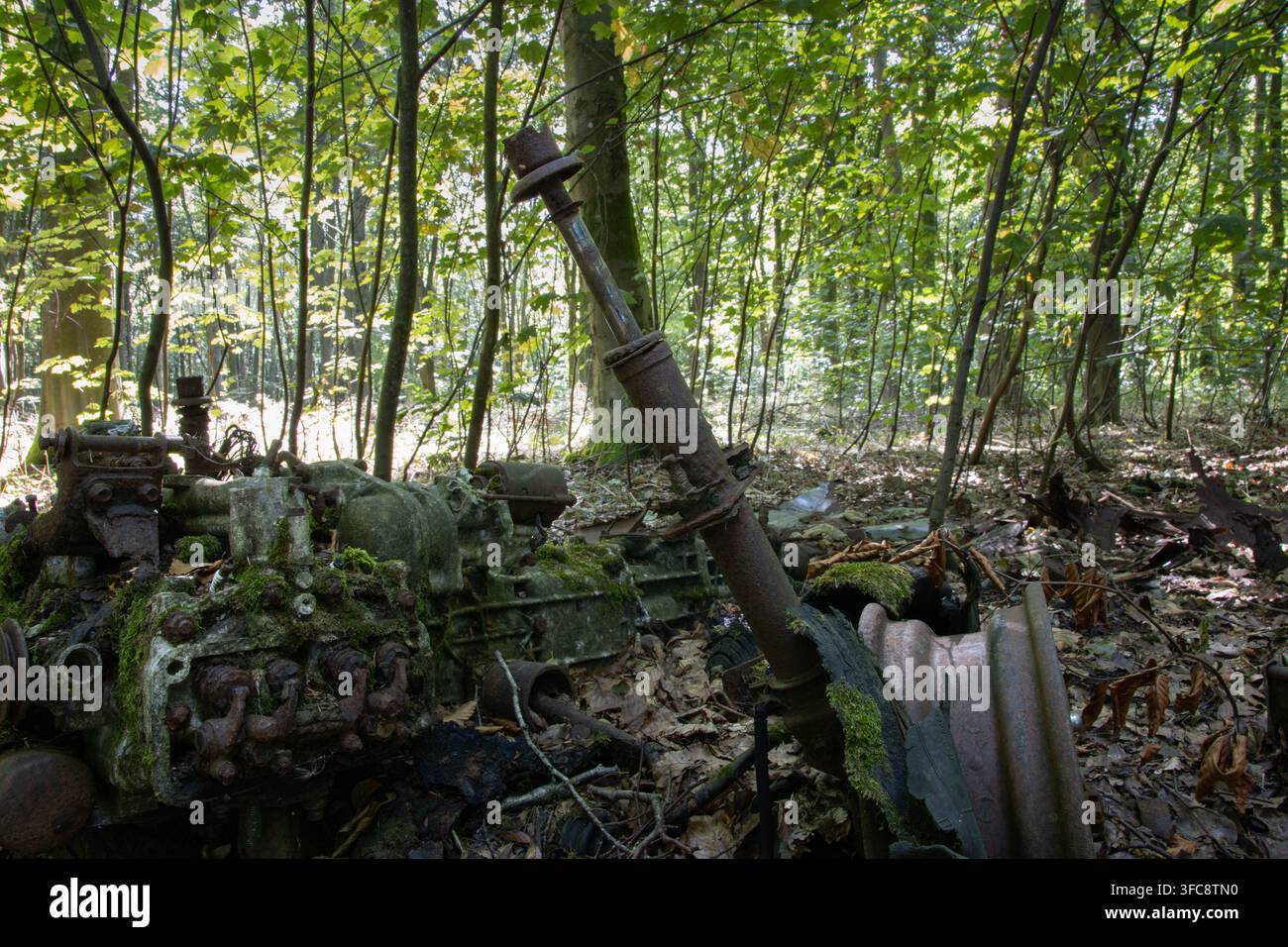 Old rusted machinery abandoned among trees and vegetation in West Woods, Wiltshire, England. Stock Photo