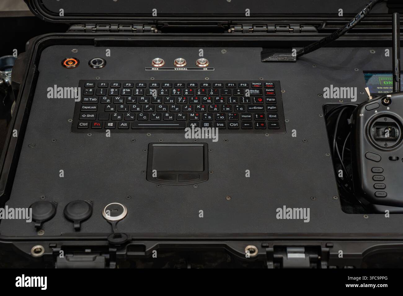Tactical UAV control station interface panel featuring integrated keyboard, touchpad, push buttons, and radio remote controller Stock Photo