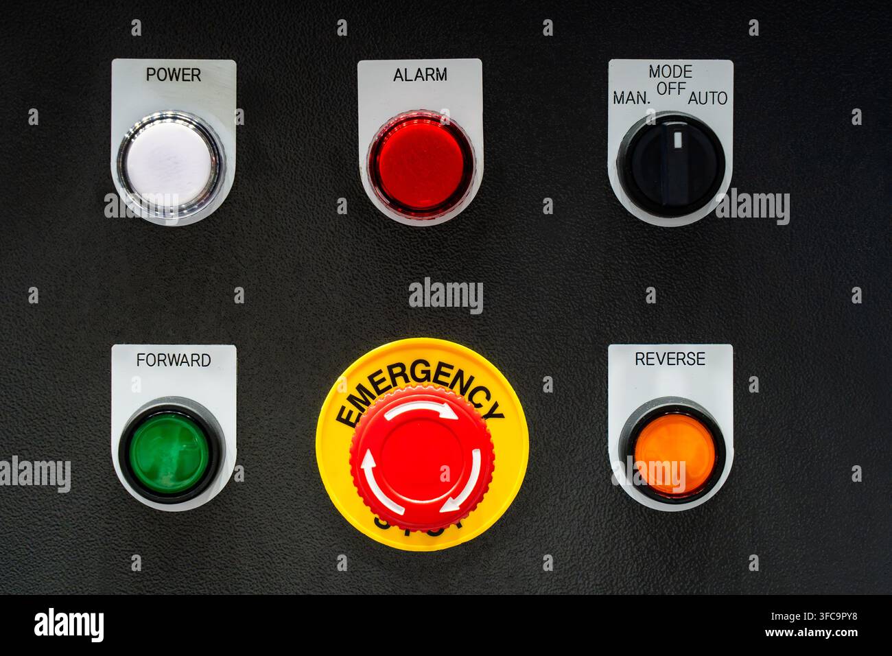 Industrial control panel with red emergency stop button, power indicator, mode switch, forward and reverse push buttons Stock Photo