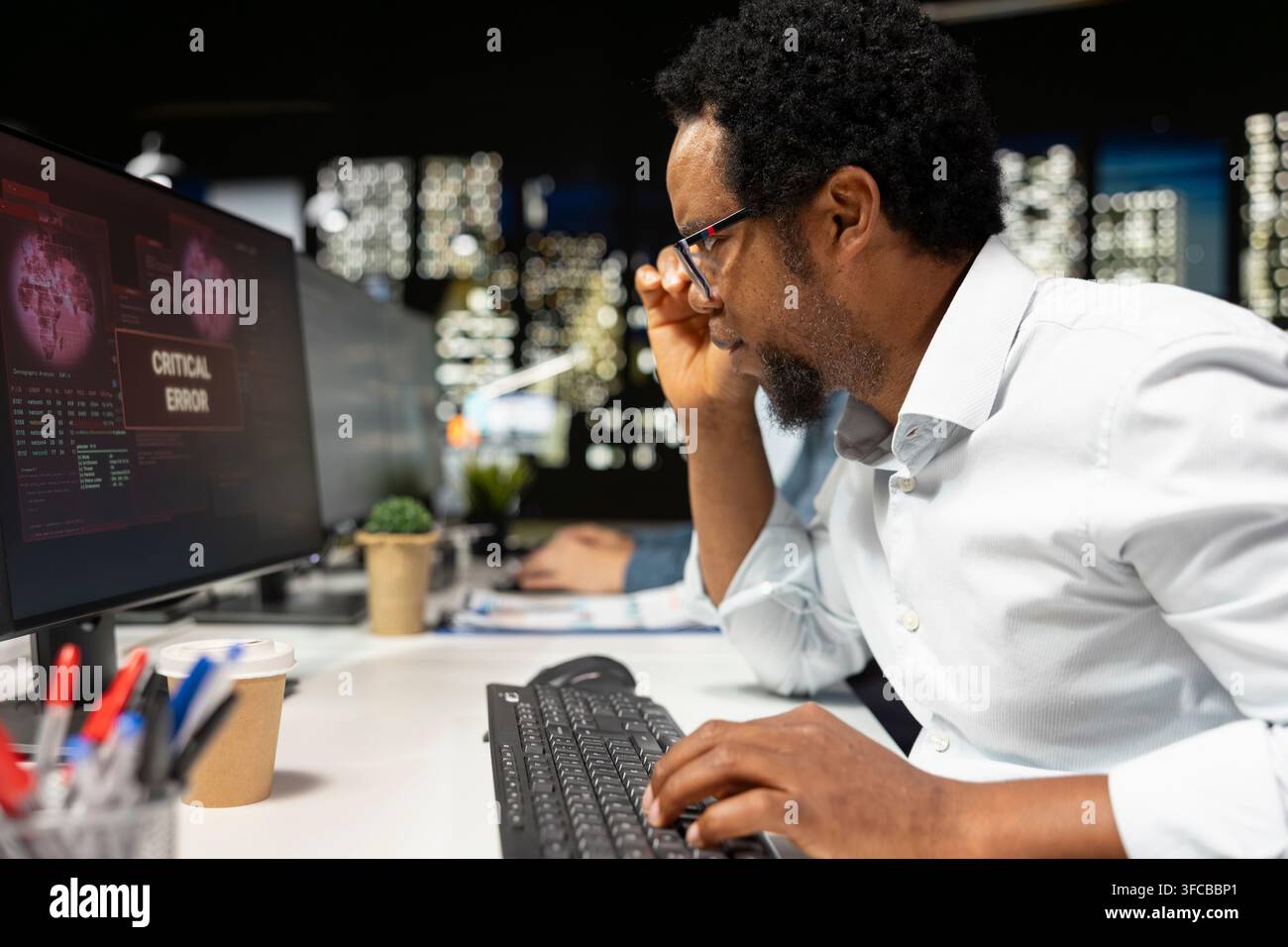 Software developer adjusting glasses, surprised by application errors while coding. African american man troubled by computer bugs while coding in sof Stock Photo