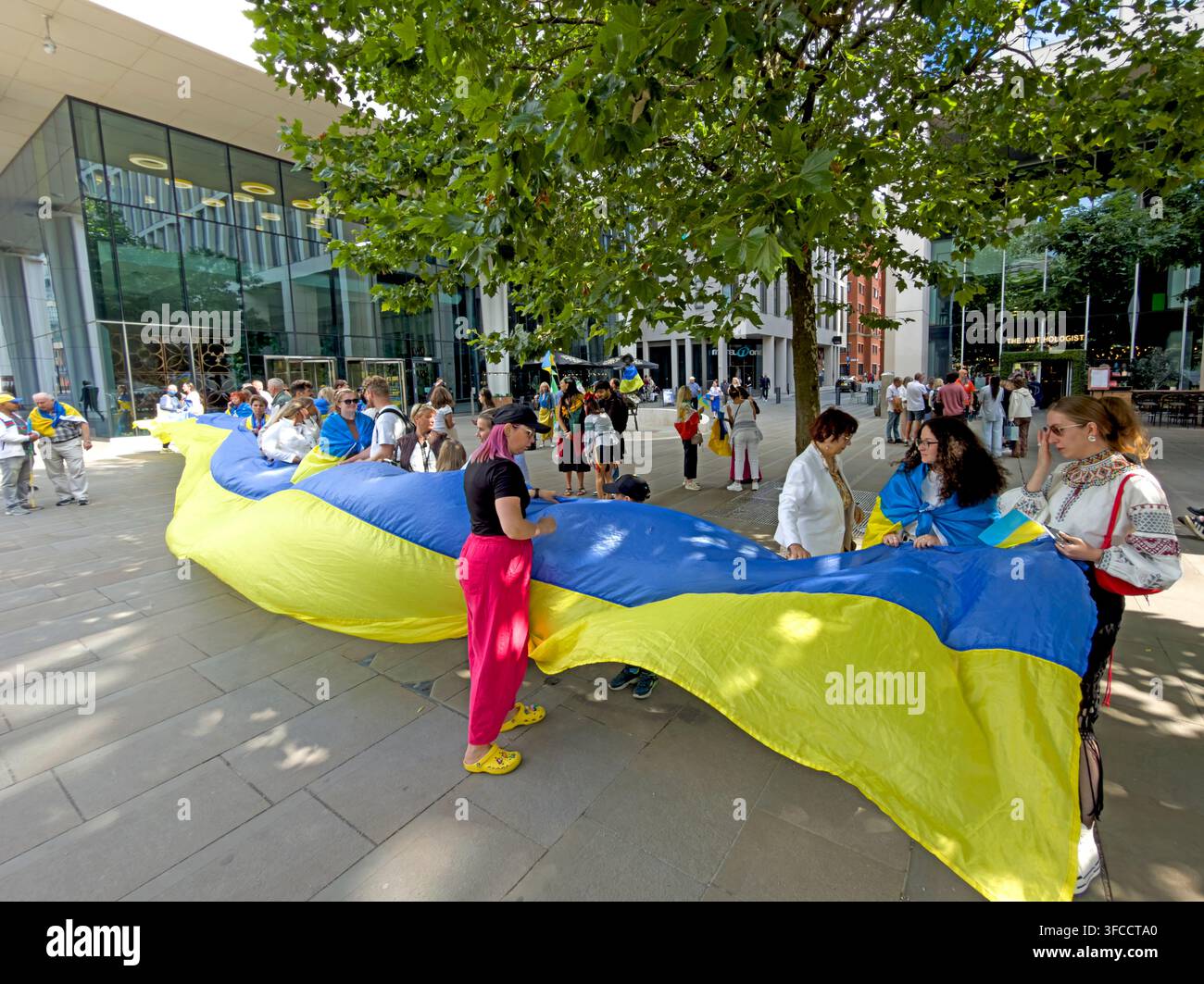 People preparing a giant blue and yellow Ukrainian flag before Manchester Independence Day gathering Stock Photo