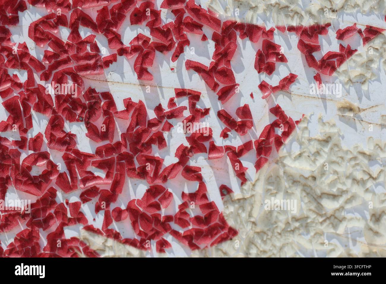 Macro Abstract Texture of Heavily Peeling and Flaking Red Paint on White Surface Stock Photo