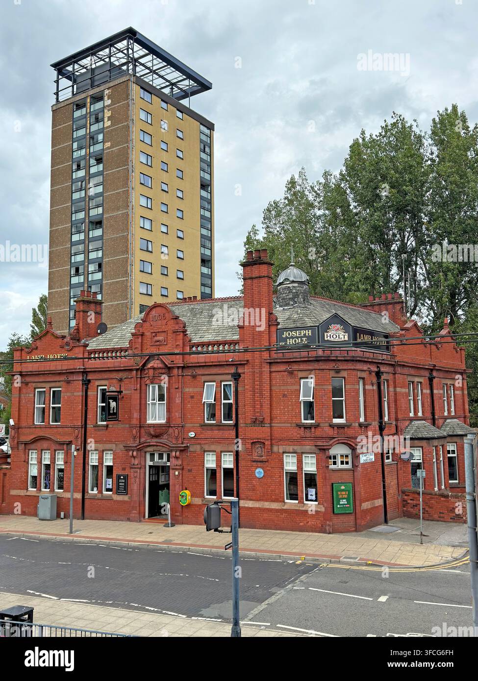 Historic red-brick civic building with high-rise tower behind in the Warrington area, Cheshire, England Stock Photo