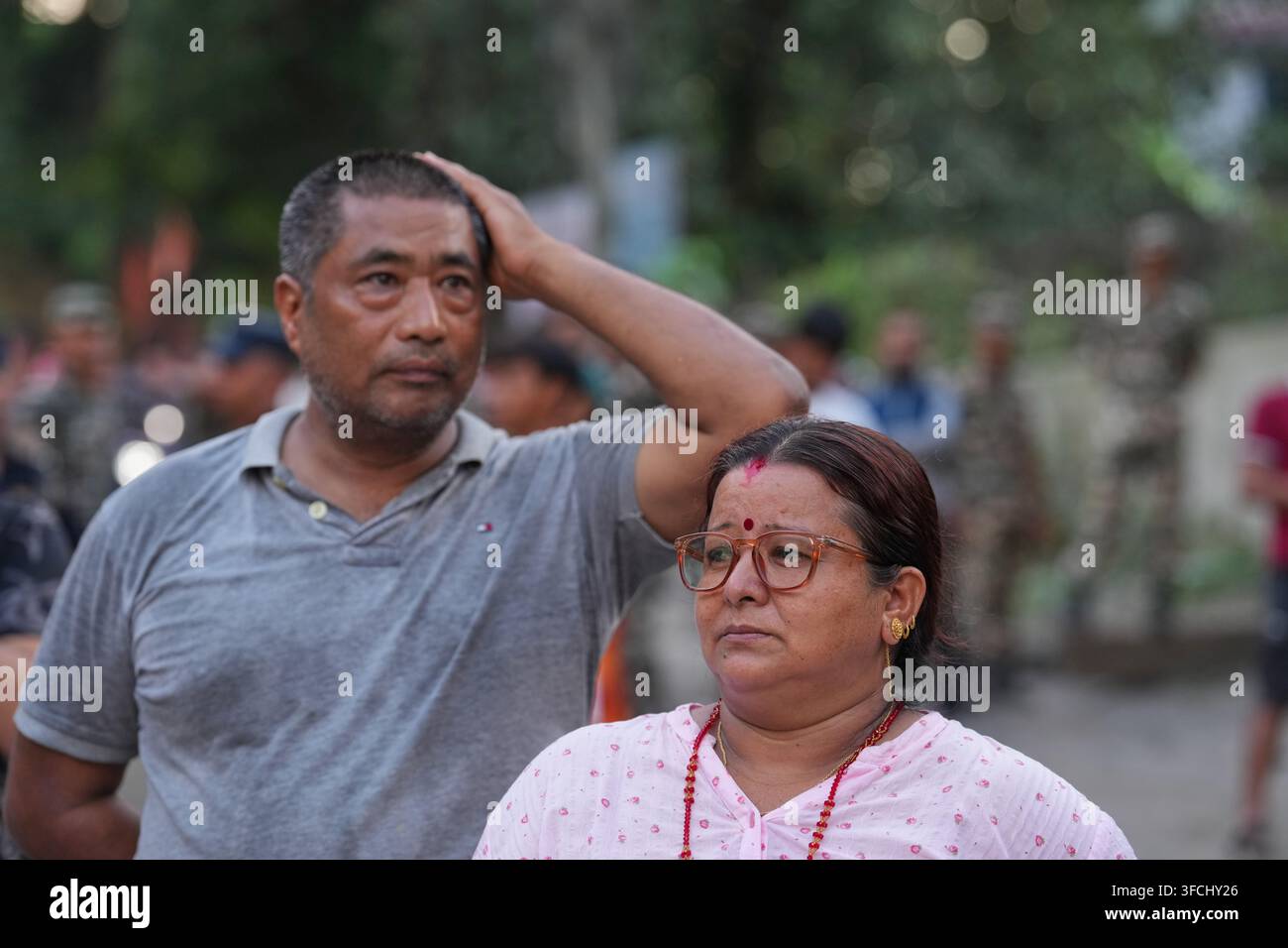 A couple stands amidst the devastation left by flash flooding in Nepal ...