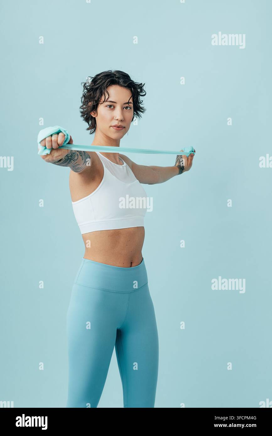 Woman practicing with a stretching band, doing arm exercises Stock Photo