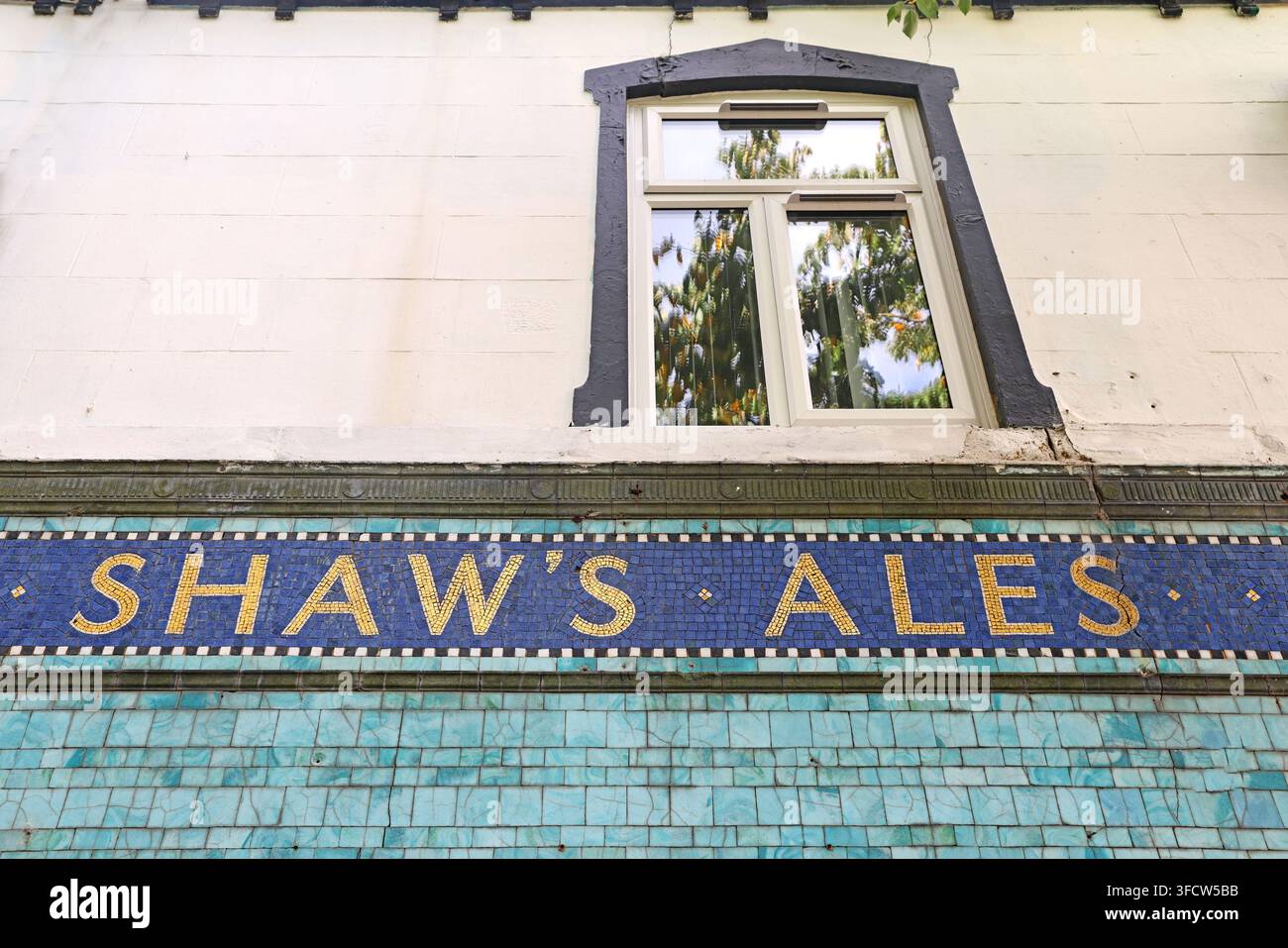 Close detail of “SHAW’S ALES” lettering in historic glazed tiles on the former Angel Hotel. Stock Photo