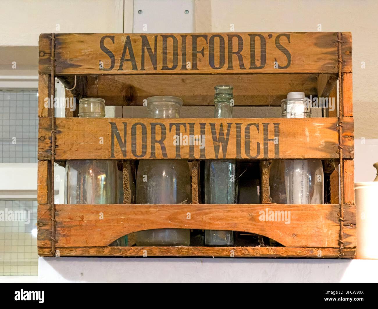 Historic Sandiford’s Northwich wooden bottle crate with vintage glass bottles. Stock Photo