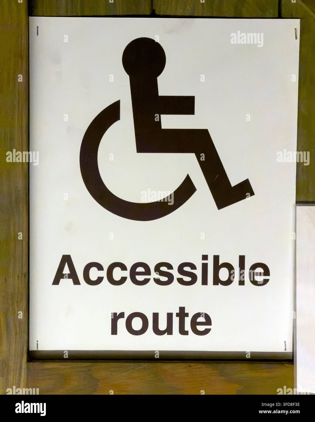 Accessible route sign with wheelchair symbol directing disabled passengers through a transport facility. Stock Photo