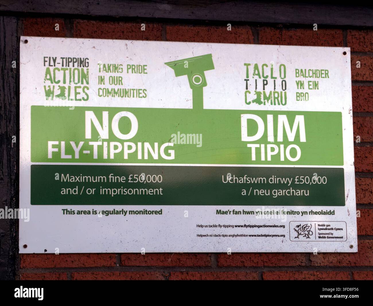 Bilingual English and Welsh “No Fly-Tipping / Dim Tipio” CCTV warning sign. Stock Photo