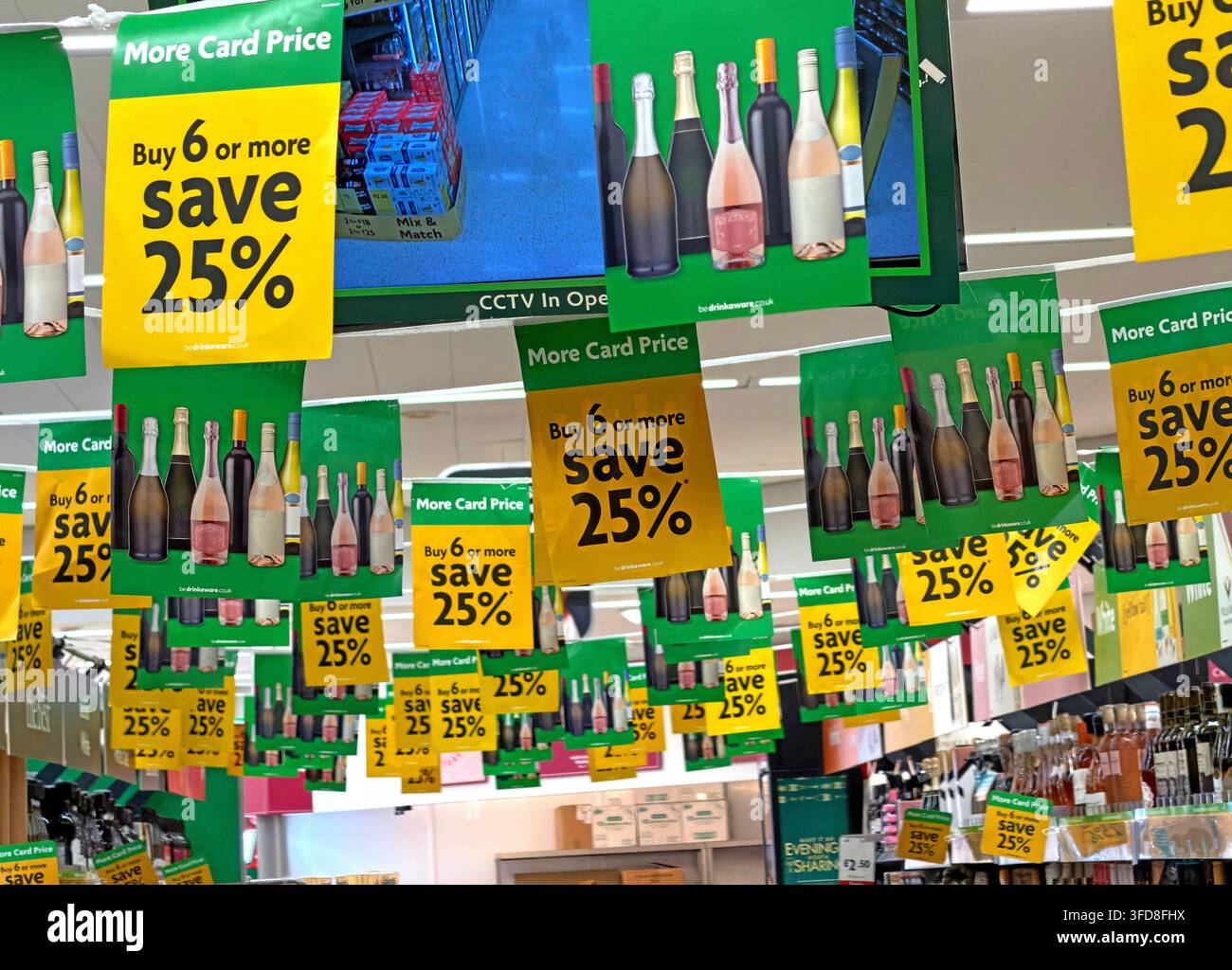 Morrisons wine aisle covered with More Card signs advertising “Buy 6 or more, save 25%”. Stock Photo