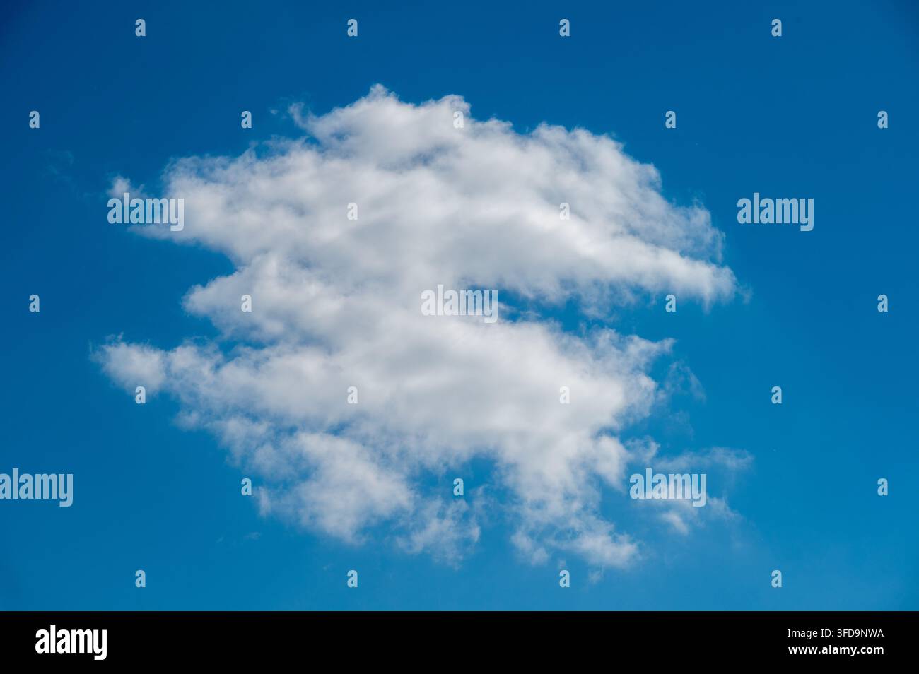 Large White Cumulus Cloud Against a Clear Blue Sky Stock Photo
