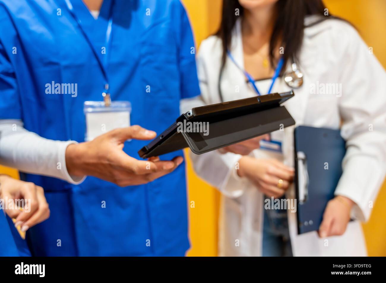 Medical team collaborating and discussing patient data using tablet Stock Photo