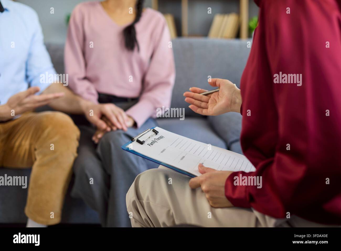 Therapist taking notes during couple counseling and relationship support session Stock Photo