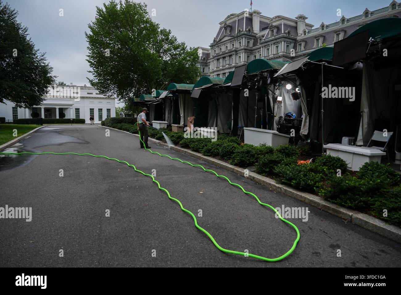 A National Park Service employee waters bushes outside the White House ...
