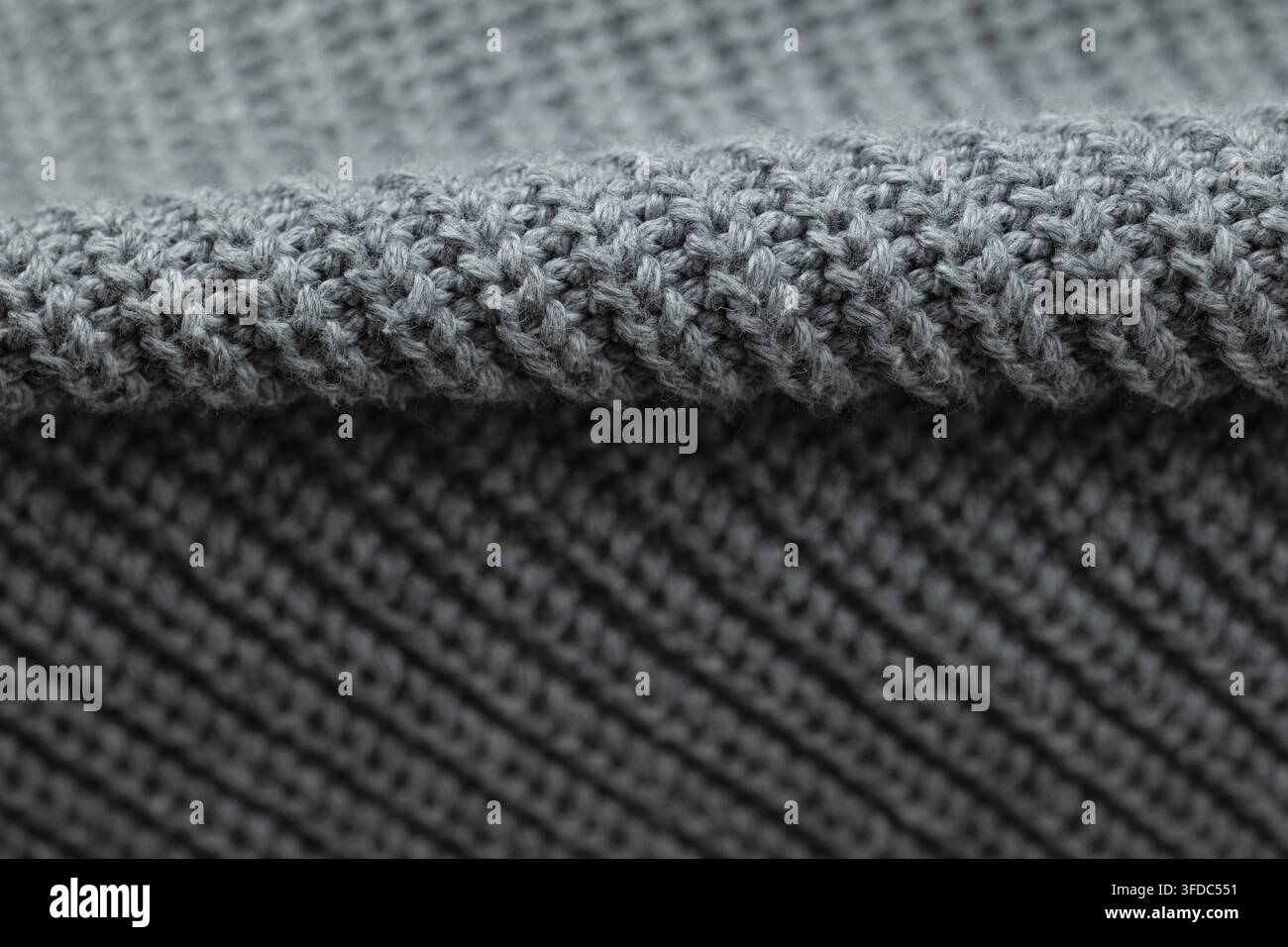 Close-up showing grey knitted textile with two different weave patterns Stock Photo