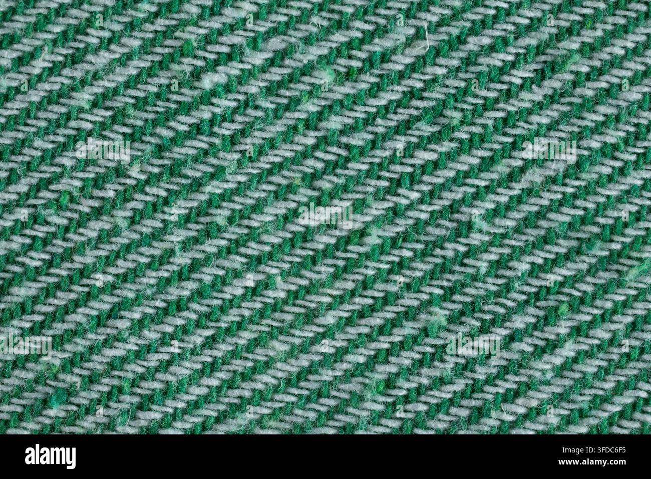 Green and white threads forming a textured diagonal pattern on woven textile material Stock Photo