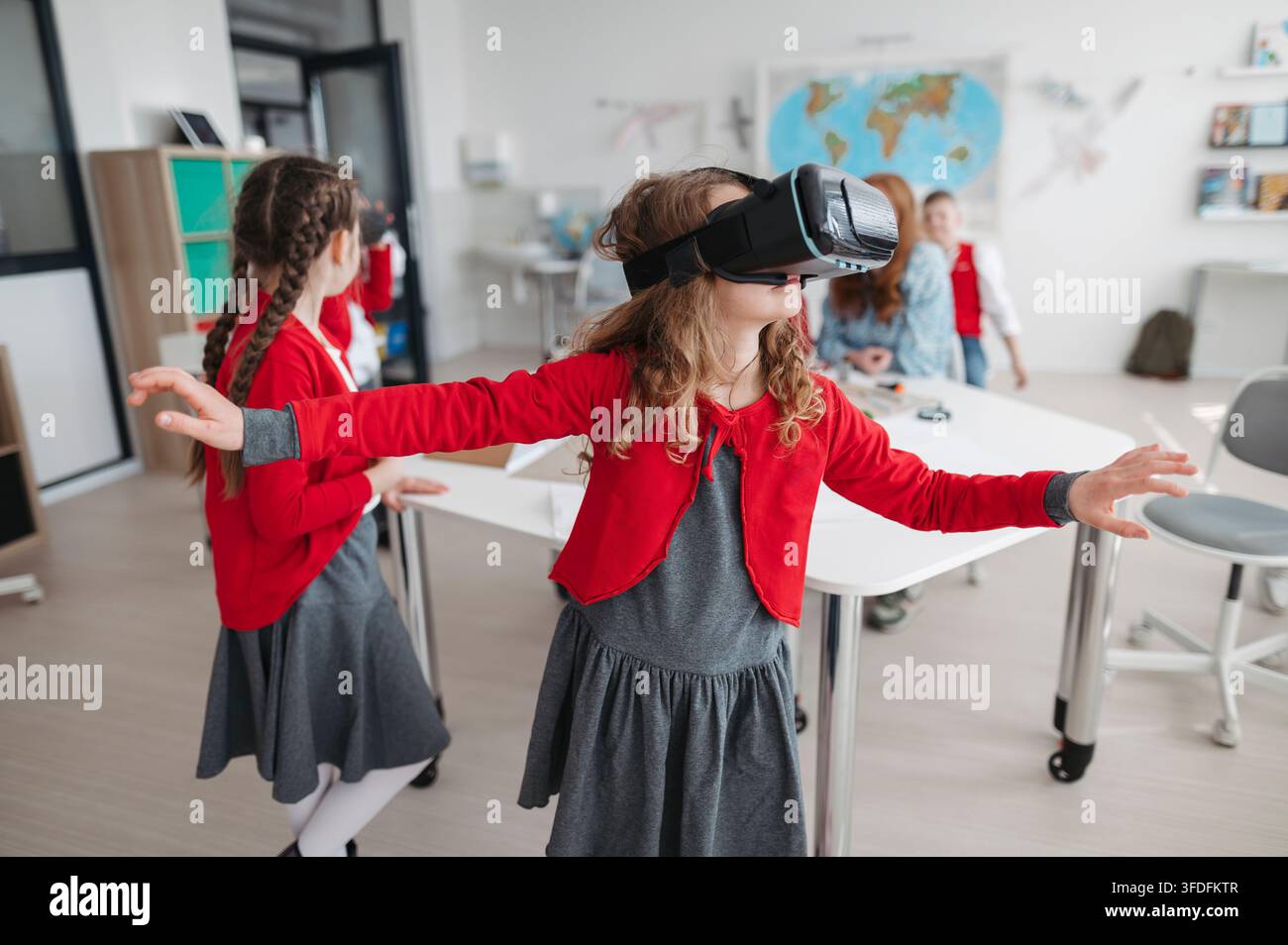 Primary school students exploring virtual reality during technology class. Stock Photo