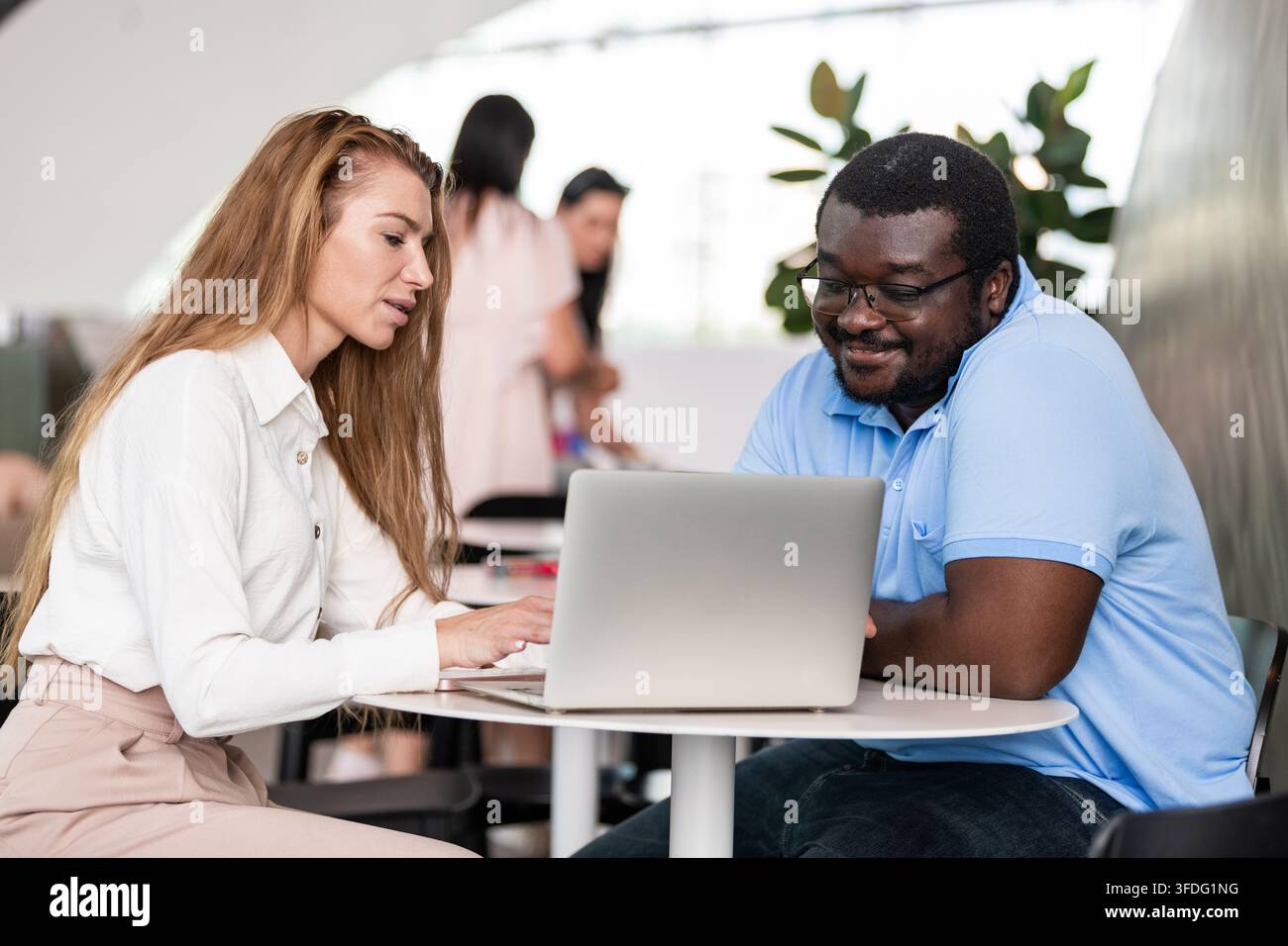 Diverse coworkers collaborating on a laptop computer Stock Photo