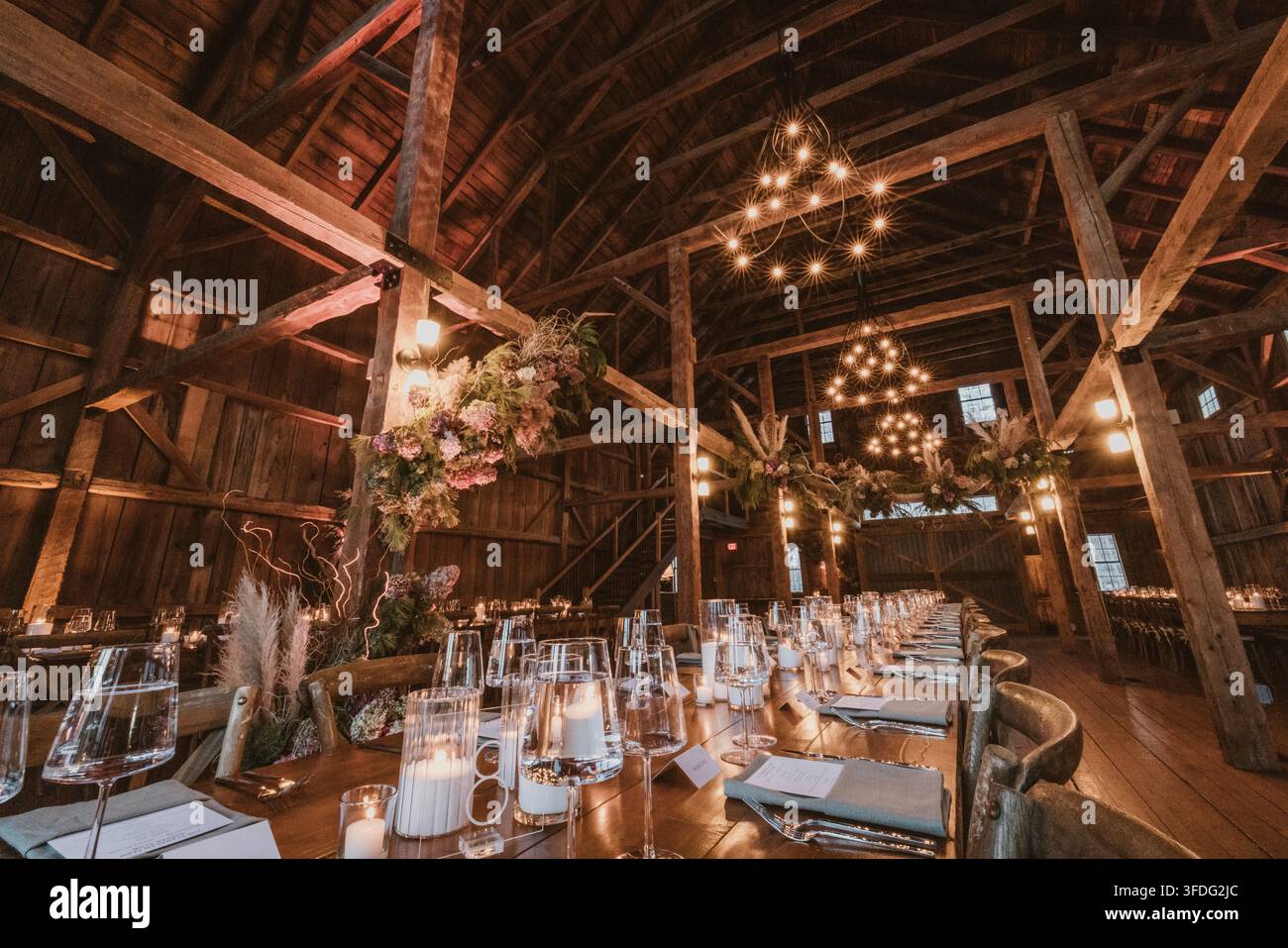 Elegant wedding reception table set in rustic barn Stock Photo