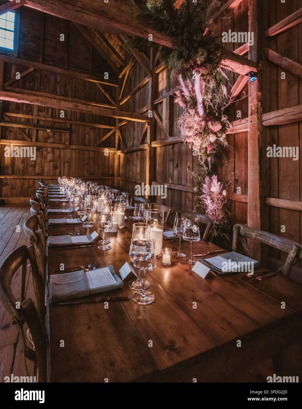Elegant rustic dinner table set inside a barn Stock Photo