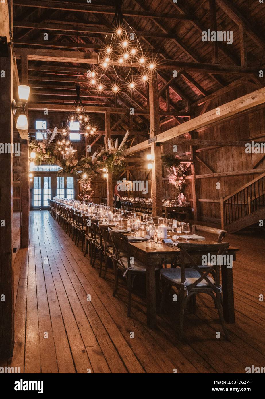 Long dining table set for a rustic barn wedding Stock Photo