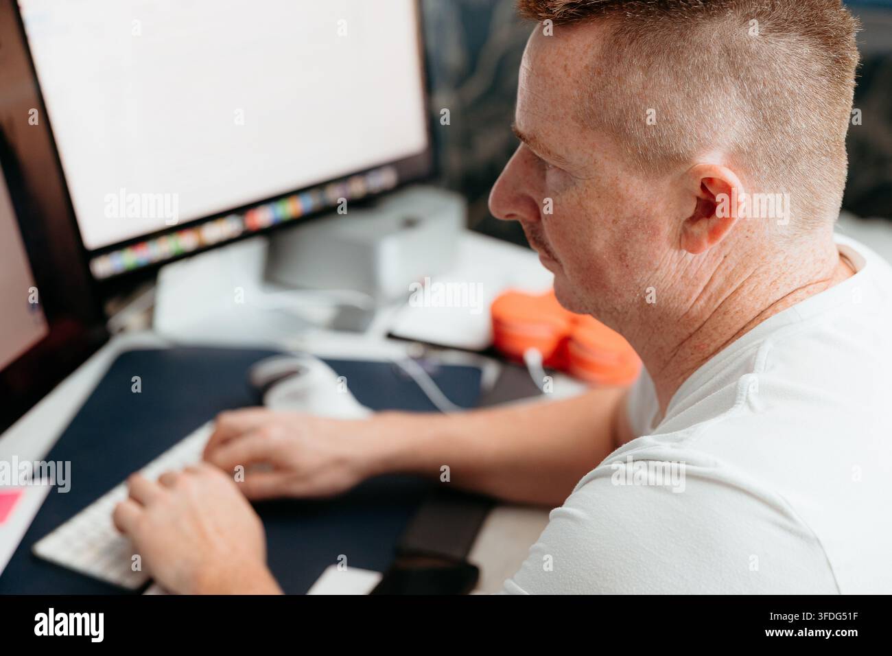 Focused man with mustache typing on computer Stock Photo