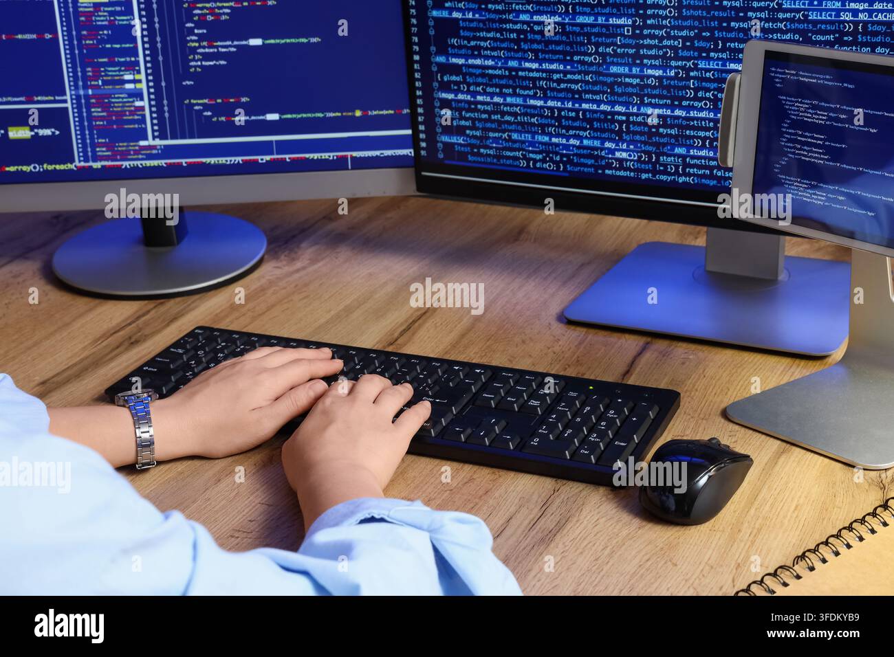 Software development and programming, developer writing code on computer with multiple monitors and tablet in office for web engineering project Stock Photo