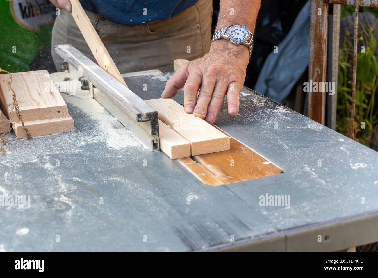 Carpenter using push stick on table saw blade close up Stock Photo