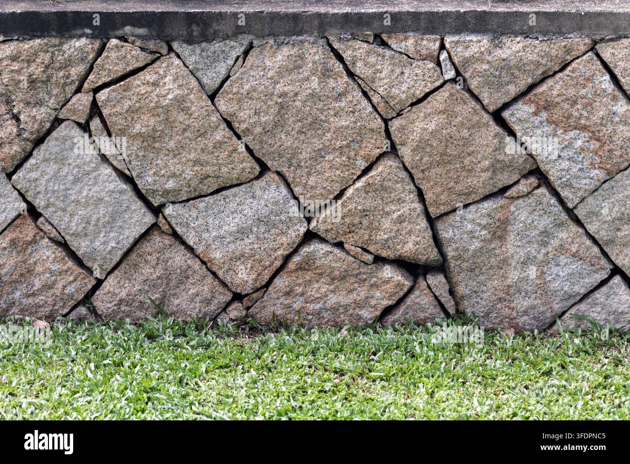 Close-up of a rustic granite stone wall with irregular fitted stones ...