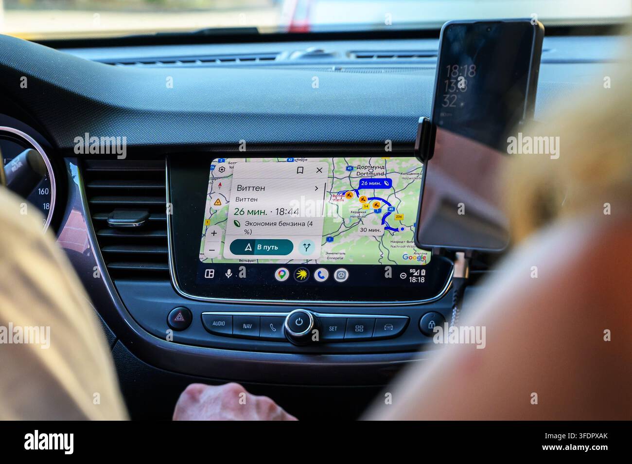 Iserlohn, Germany - August 13, 2026: Car interior with navigation system displaying a map to Witten and smartphone mounted on dashboard. Stock Photo