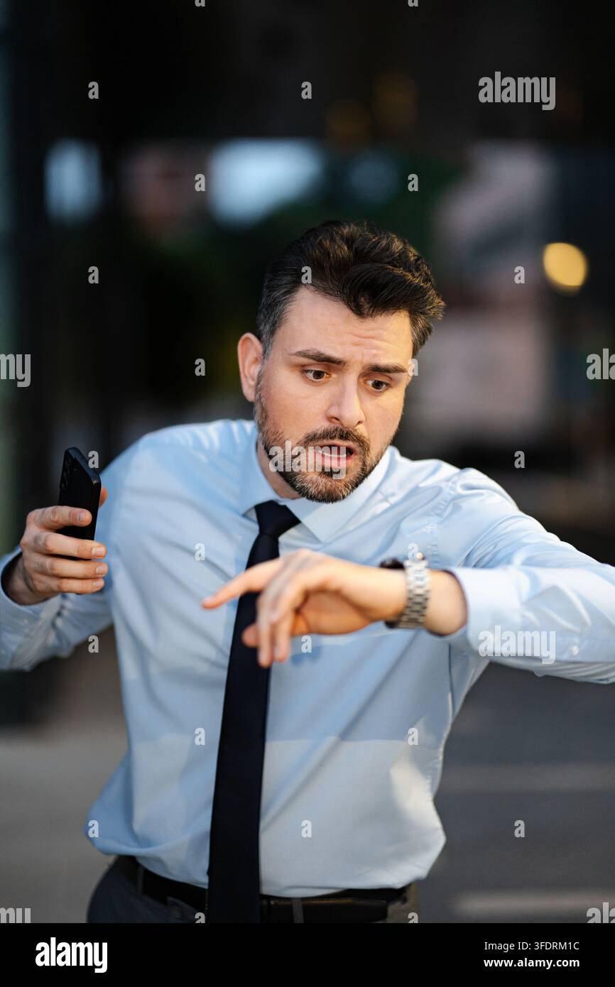 Stressed businessman checking watch realizing time running out Stock Photo