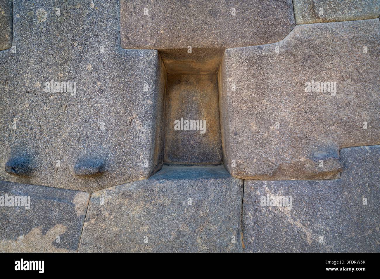 Close-up of ancient Inca interlocking stone wall with a small ...