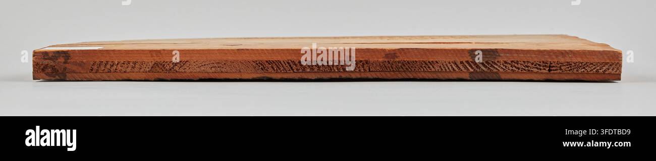 A rectangular wooden block with a flat top surface and a side edge ...
