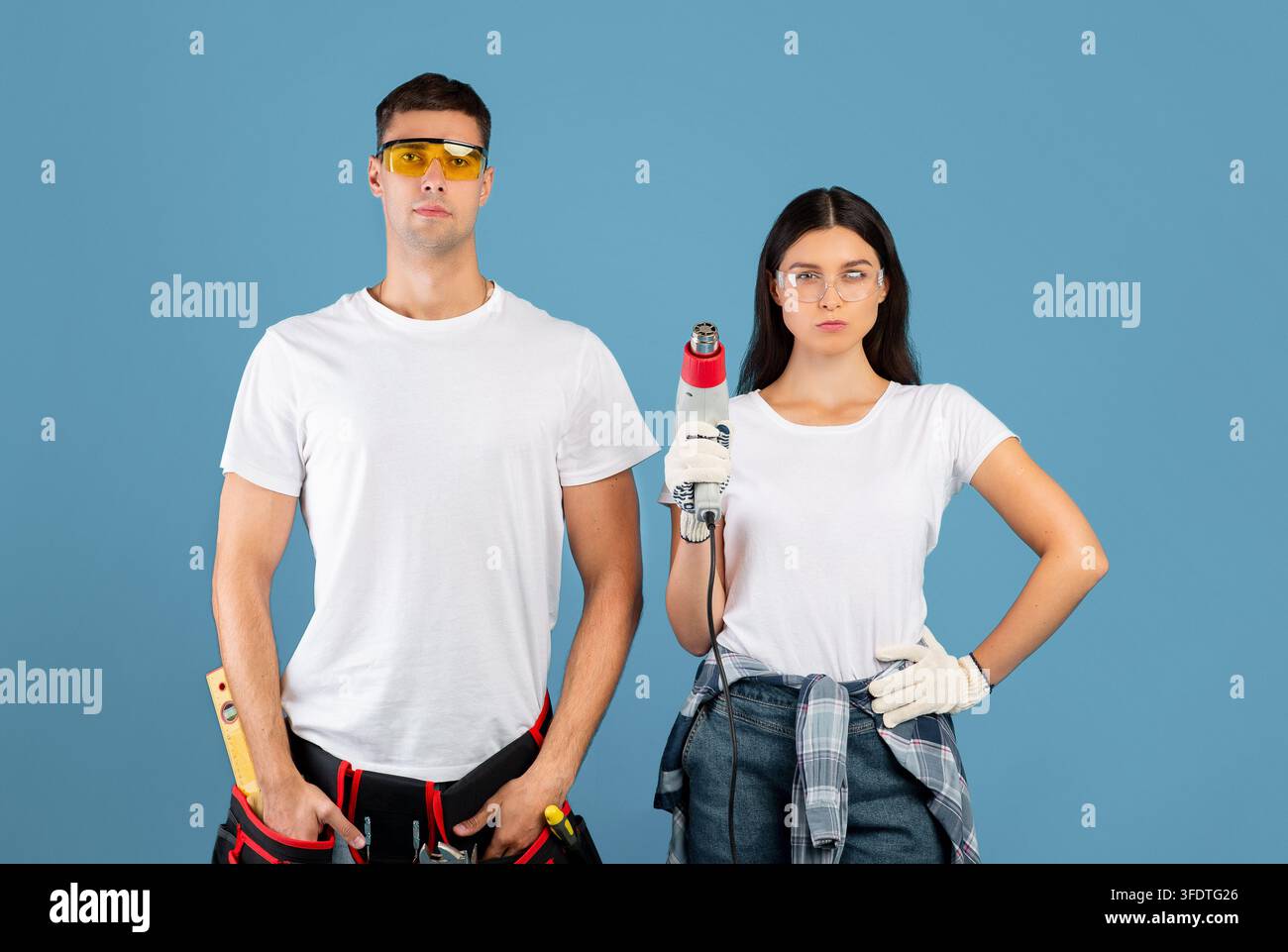 Ready For Renovation. Confident Couple Of Repair Workers Holding Construction Dryer Stock Photo