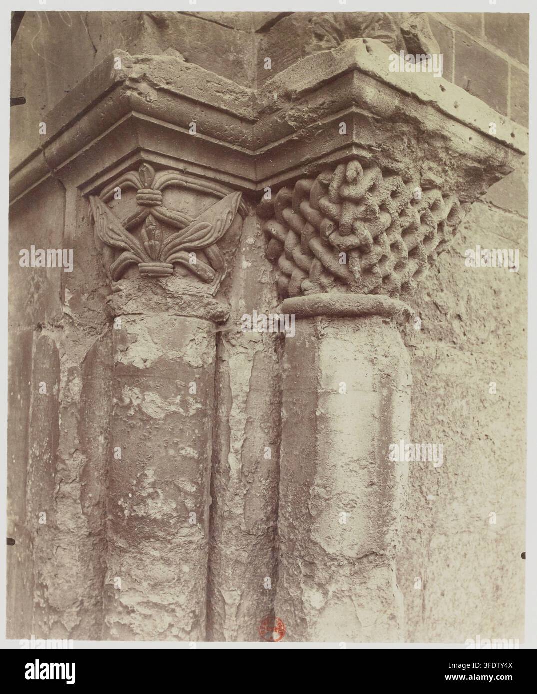 A close-up photograph of two stone columns with carved capitals, one ...