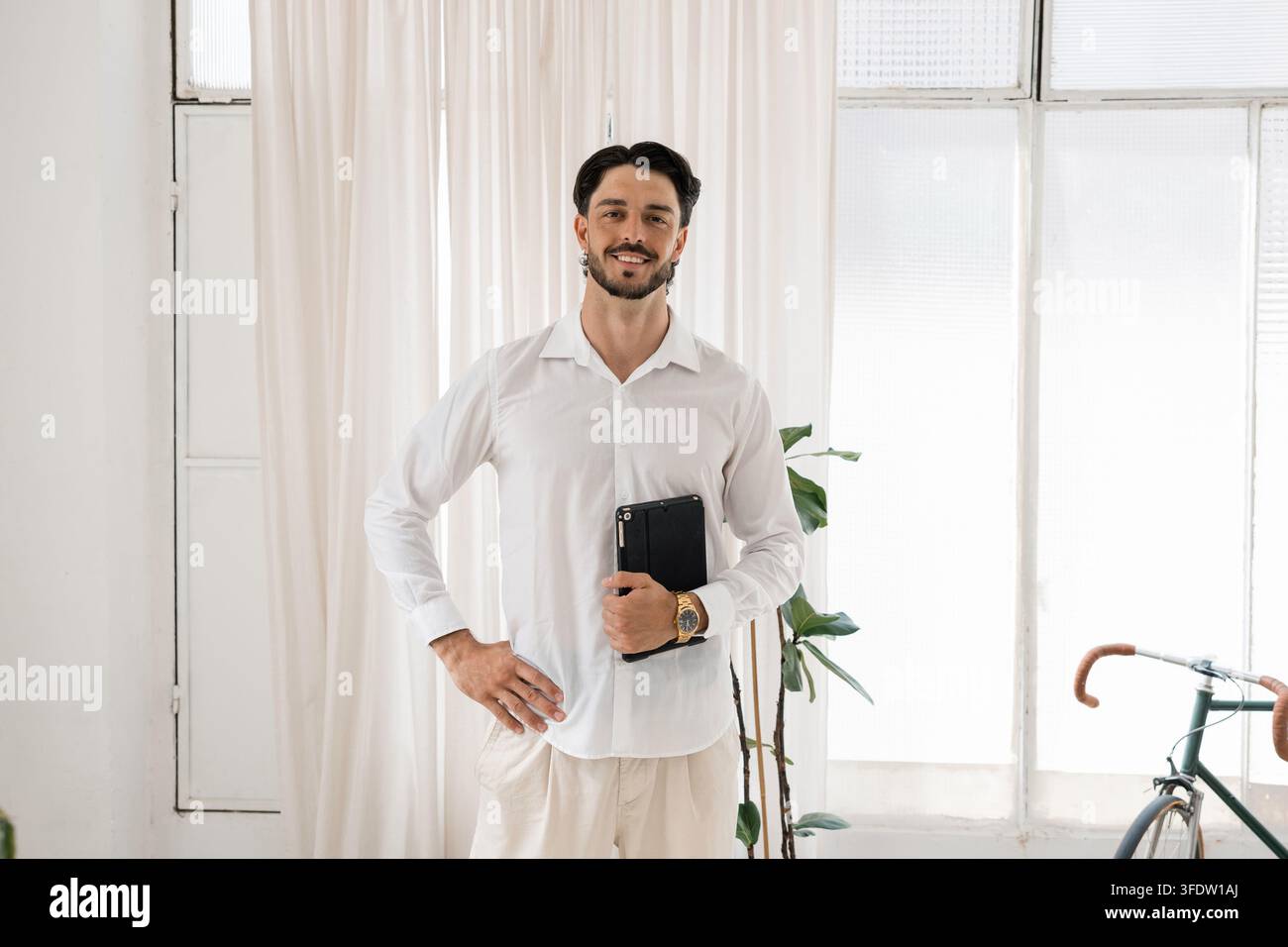 Young professional man smiling holding digital tablet Stock Photo