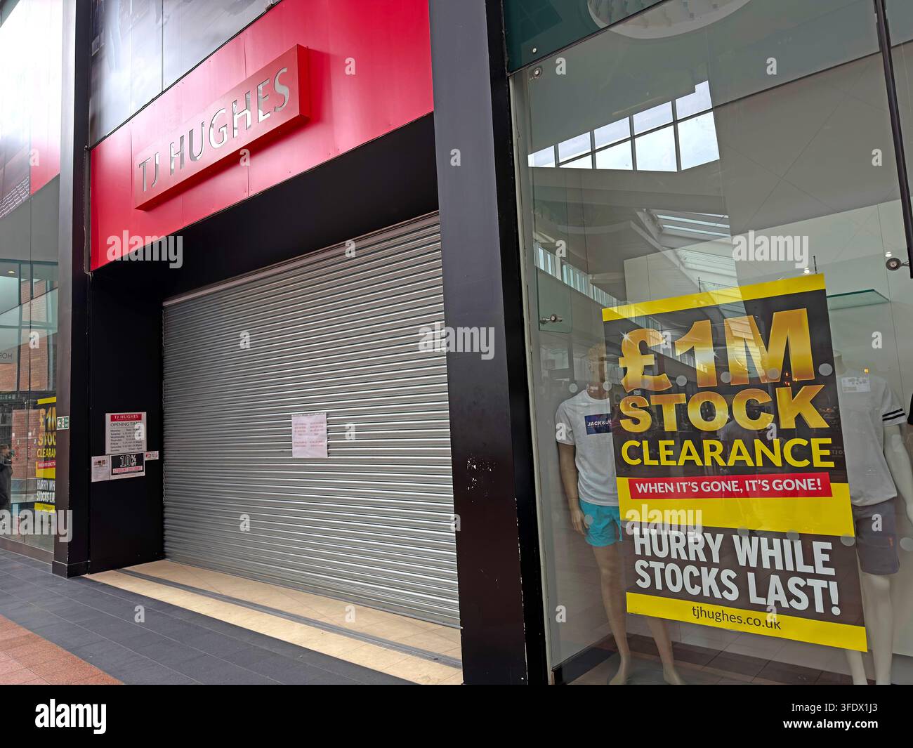 TJ Hughes department store at Golden Square, Warrington, with stock-clearance posters during retail uncertainty Stock Photo