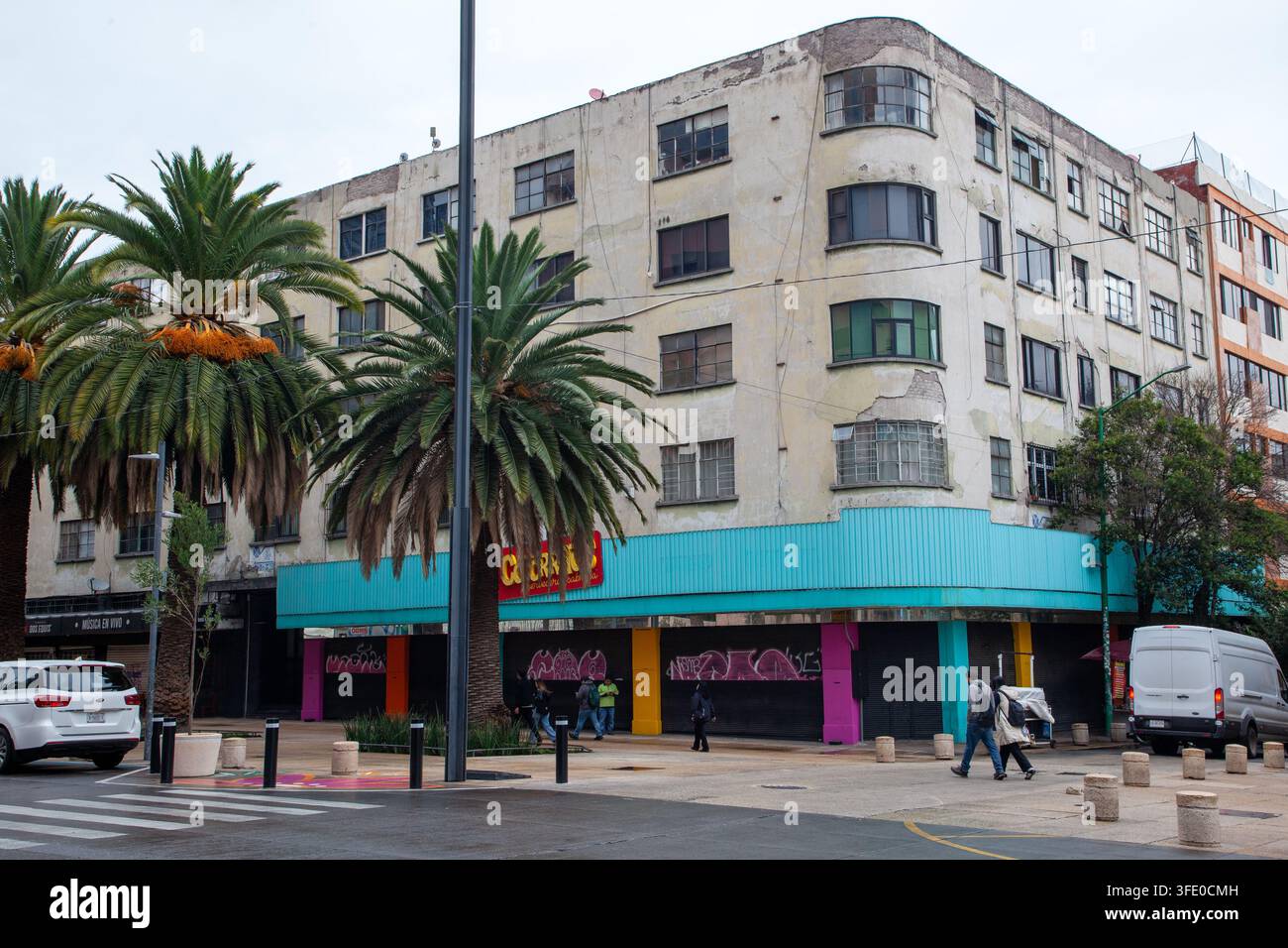 multi-story, weathered building on a city street corner in Mexico City Stock Photo