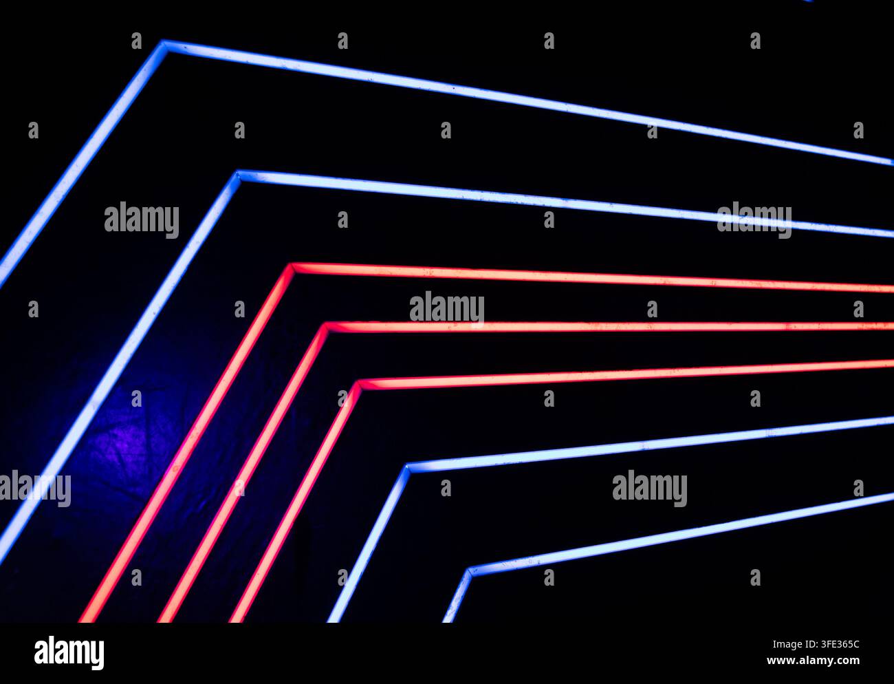 Glowing neon stripped lights on dark background Stock Photo