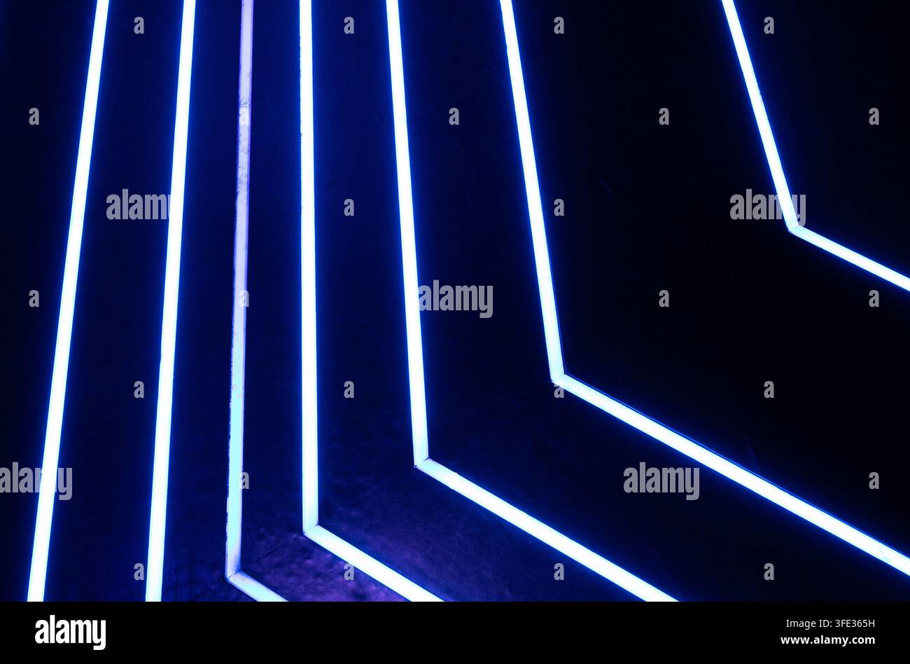 Glowing neon stripped lights on dark background Stock Photo