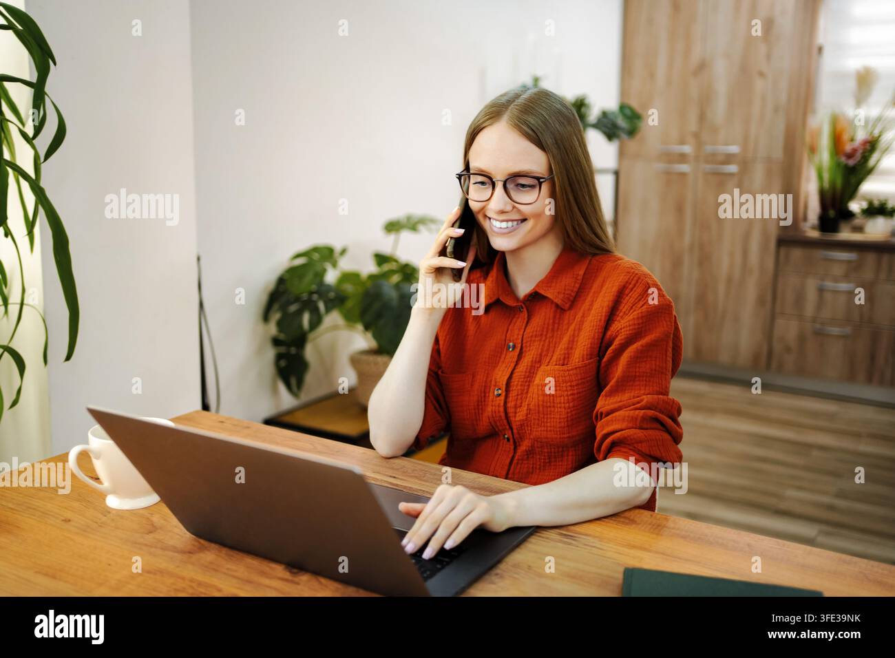 Young woman multitasking working from home office Stock Photo