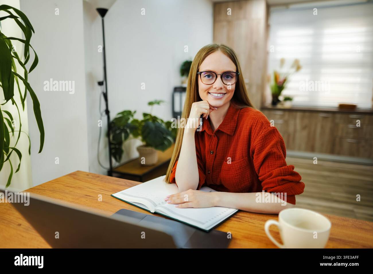 Young woman working remotely from her comfortable home office Stock Photo
