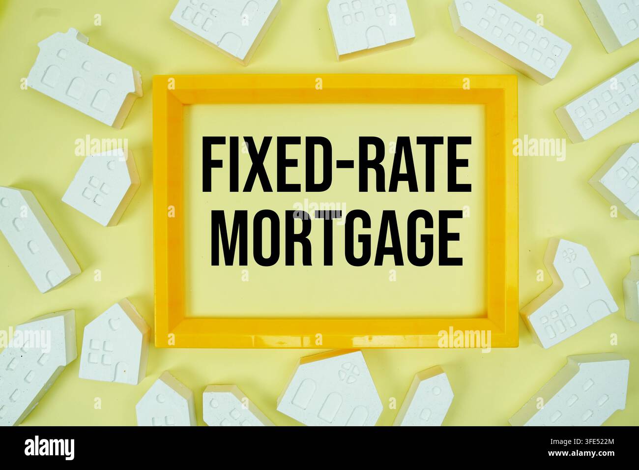 Fixed-Rate Mortgage text with house models on yellow background Stock Photo