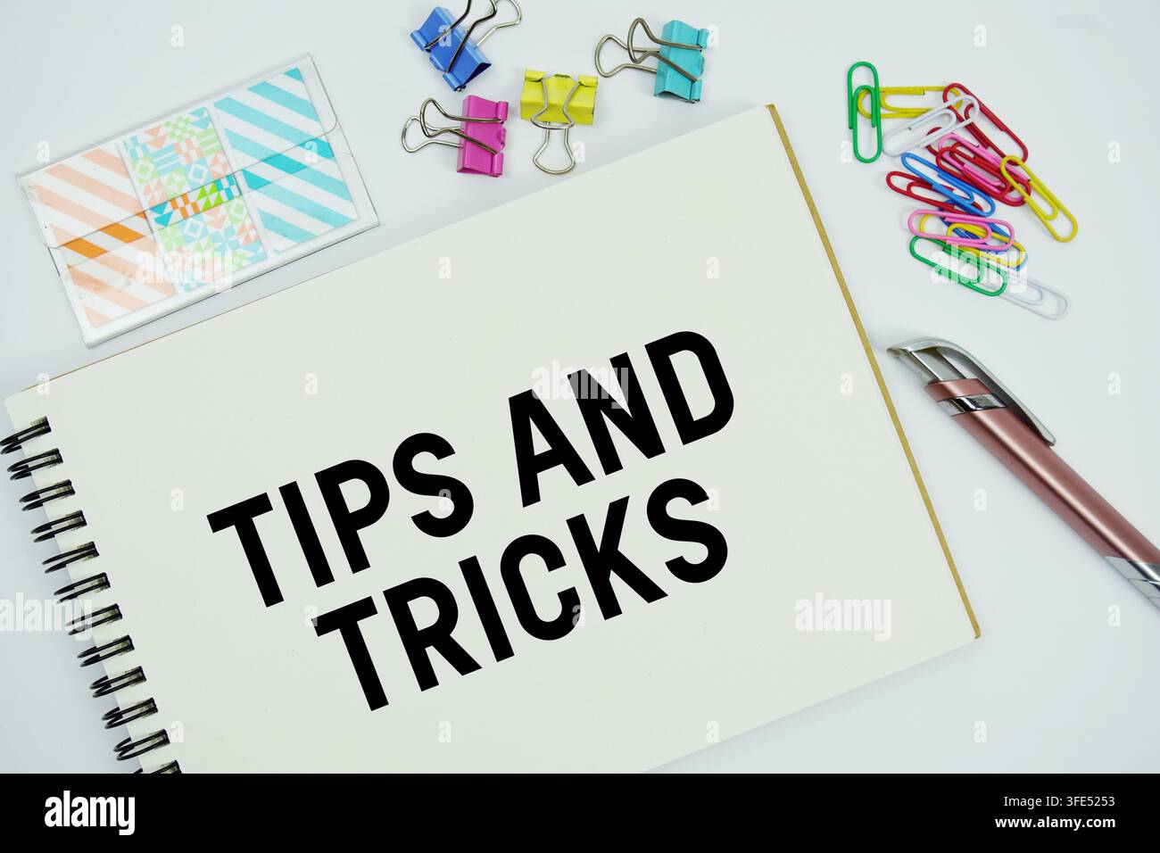 Tips And Tricks text message written on notepad with stationery flat lay on white background Stock Photo